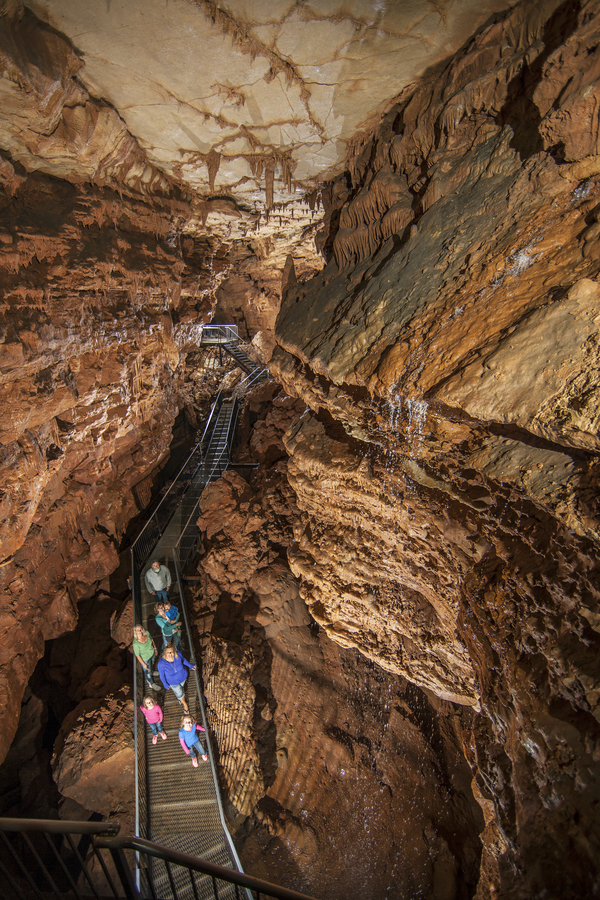 Group of Indiana Cave visitors standing by waterfall